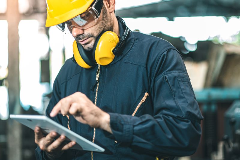 Investigação de acidente de trabalho: técnico de segurança do trabalho usando tablet.