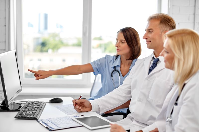 NR-7 o que é: equipe médica verificando informações em computador