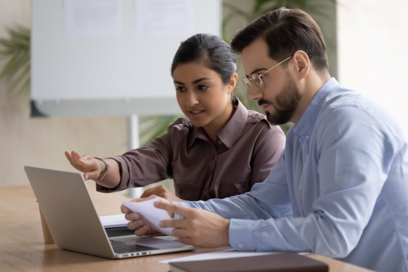 consulta de qualificação cadastral: mulher explicando a homem sobre o eSocial no escritório