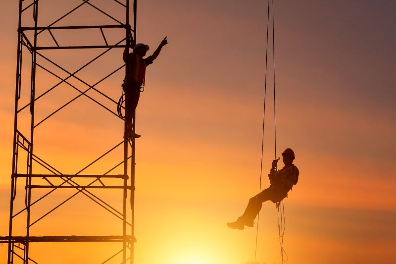 validade da NR-35​: dois trabalhadores em torre de energia